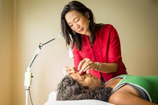 Woman performing acupuncture on patient